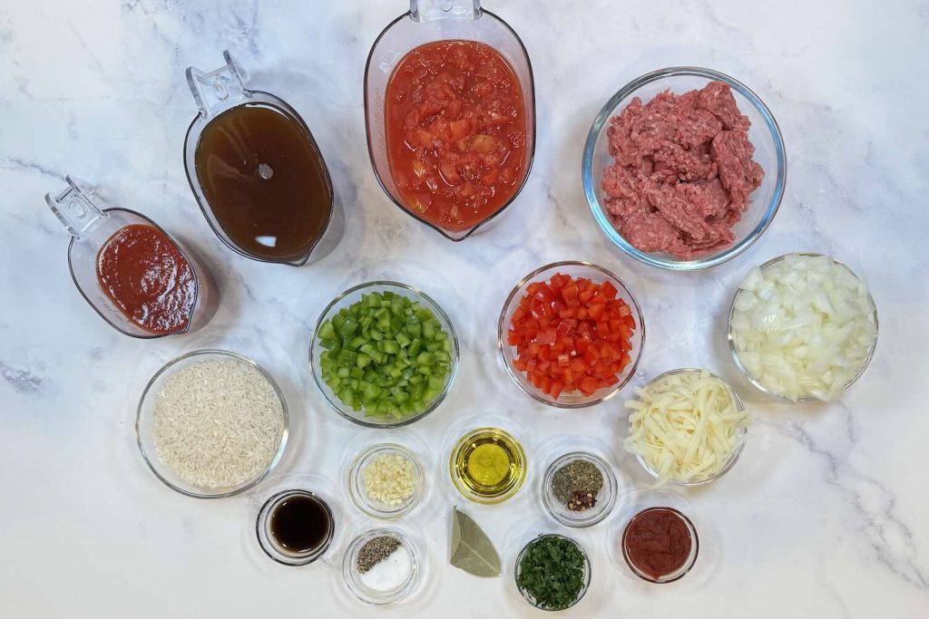 Ingredients for stuffed pepper soup including ground beef, white rice, diced tomatoes, beef broth, tomato sauce, tomato paste, green and red bell peppers, onion, garlic, olive oil, Worcestershire sauce, bay leaf, parsley, salt, and black pepper.