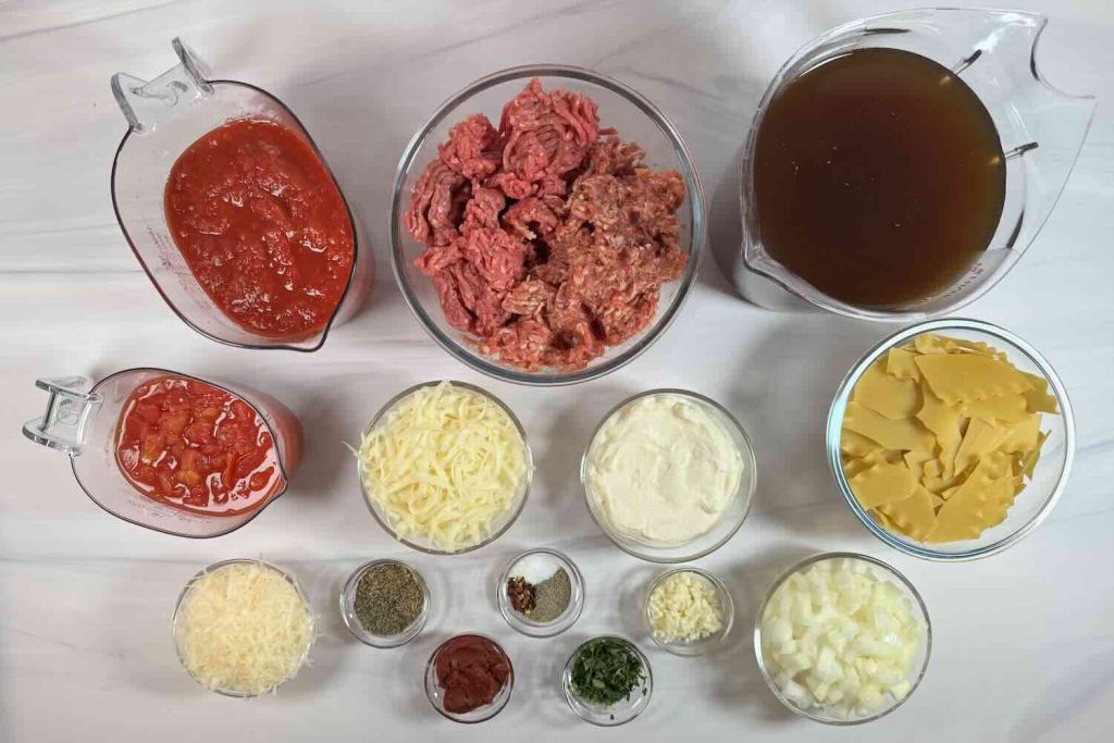 Ingredients for lasagna soup including ground beef, lasagna noodles, crushed tomatoes, diced tomatoes, beef broth, onion, garlic, ricotta, mozzarella, Parmesan, tomato paste, and Italian seasonings.